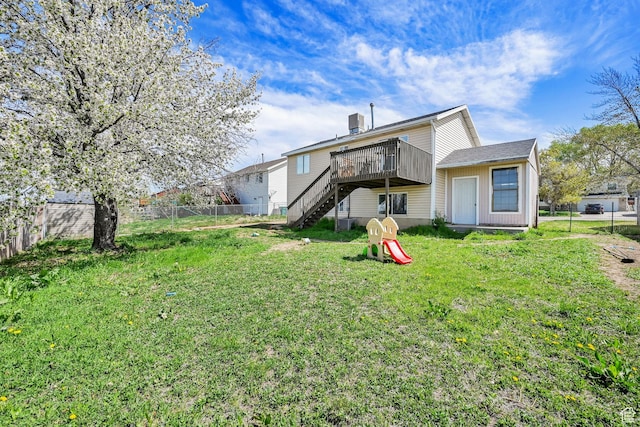 view of yard with a fenced backyard, a wooden deck, and stairway