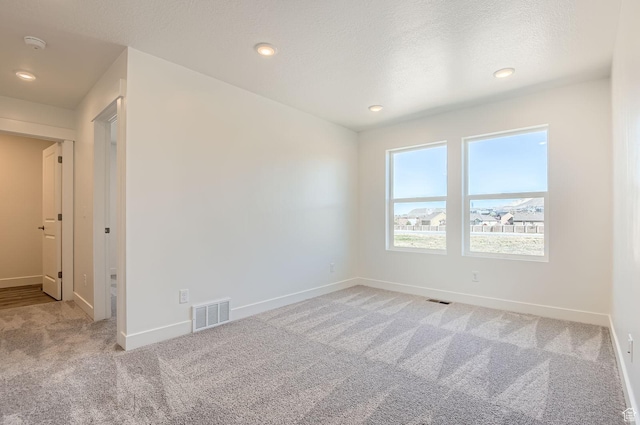 unfurnished room featuring visible vents, baseboards, recessed lighting, and light carpet