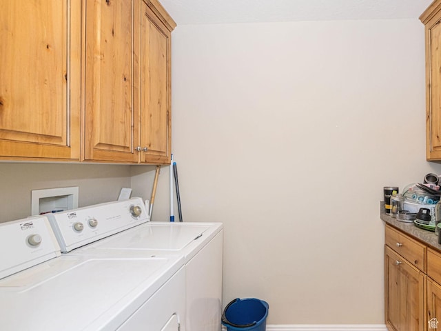 laundry room featuring washing machine and clothes dryer and cabinet space