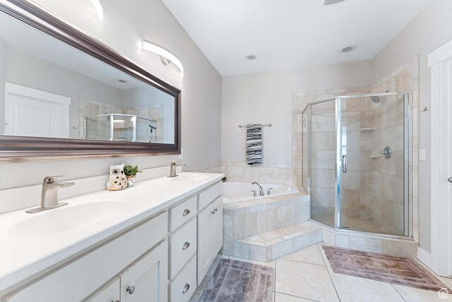 full bathroom featuring a shower stall, a bath, tile patterned flooring, and a sink