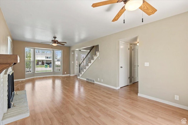 282 E 9545 S, Sandy, UT 84070 - unfurnished living room with visible vents, ceiling fan, light wood-type flooring, a fireplace, and stairway