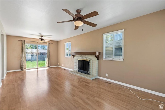 282 E 9545 S, Sandy, UT 84070 - unfurnished living room featuring visible vents, baseboards, a brick fireplace, a ceiling fan, and wood finished floors