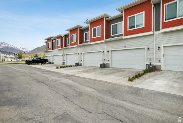 exterior space featuring central AC, a mountain view, a garage, and driveway