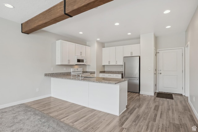 kitchen featuring baseboards, white appliances, light wood-style floors, and light stone countertops