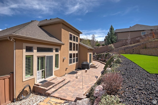 back of house with a patio, a fenced backyard, stucco siding, and roof with shingles