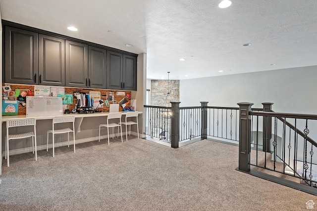 interior space featuring recessed lighting, light colored carpet, a kitchen bar, and a textured ceiling