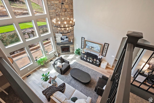 living area with wood finished floors, a towering ceiling, baseboards, and a notable chandelier