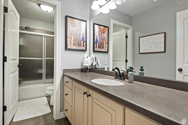 full bathroom featuring toilet, a textured ceiling, vanity, shower / bath combination with glass door, and tile patterned floors