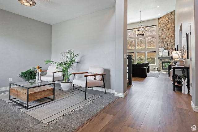 living area featuring hardwood / wood-style floors, baseboards, and a notable chandelier