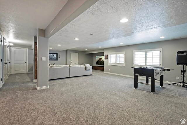 recreation room featuring a textured ceiling, carpet, and recessed lighting