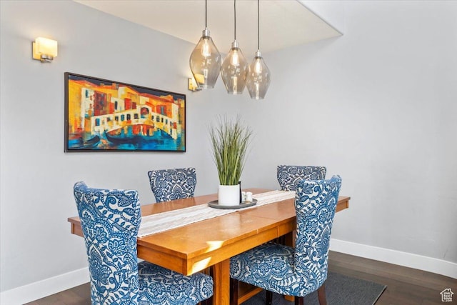 dining room featuring wood finished floors, an inviting chandelier, and baseboards