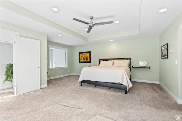 carpeted bedroom featuring baseboards, recessed lighting, a raised ceiling, and a ceiling fan