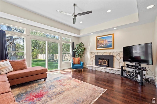 living room with recessed lighting, a stone fireplace, a ceiling fan, and wood finished floors