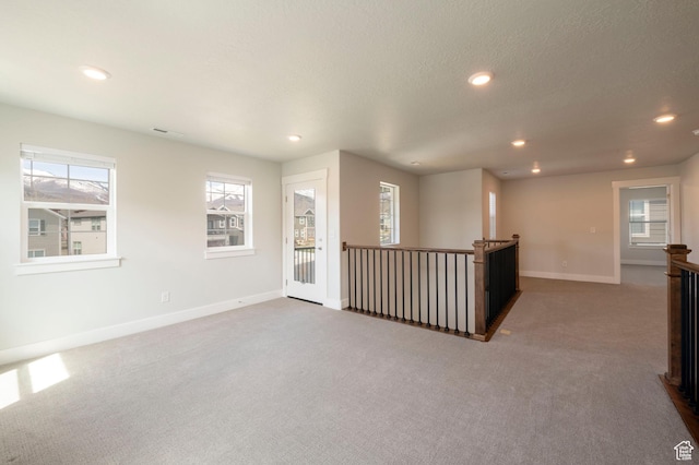 spare room featuring recessed lighting, carpet flooring, baseboards, and a textured ceiling