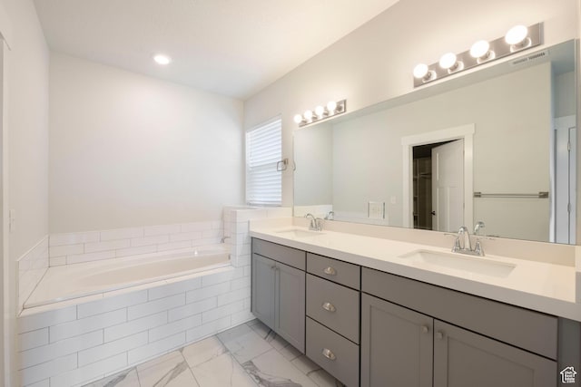 bathroom with a sink, visible vents, marble finish floor, and a garden tub