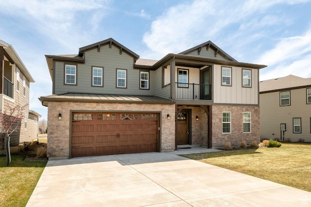 view of front of property featuring driveway, stone siding, a front yard, a garage, and a standing seam roof