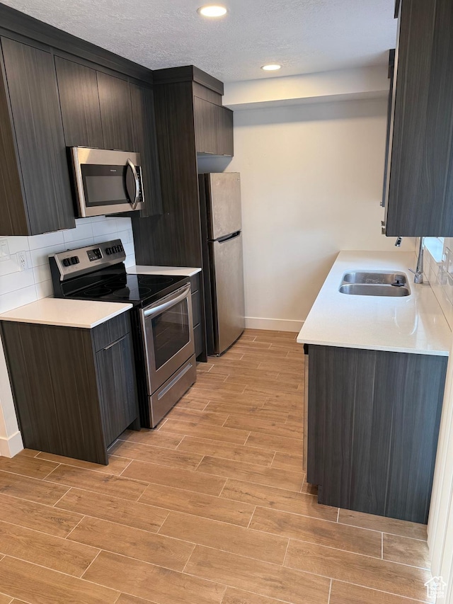 3049 S Orchard Dr Unit B, Bountiful, UT 84010 - kitchen with baseboards, light countertops, light wood-style floors, stainless steel appliances, and a sink
