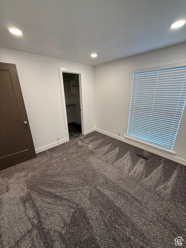 3049 S Orchard Dr Unit B, Bountiful, UT 84010 - unfurnished bedroom featuring recessed lighting, dark colored carpet, a spacious closet, and baseboards
