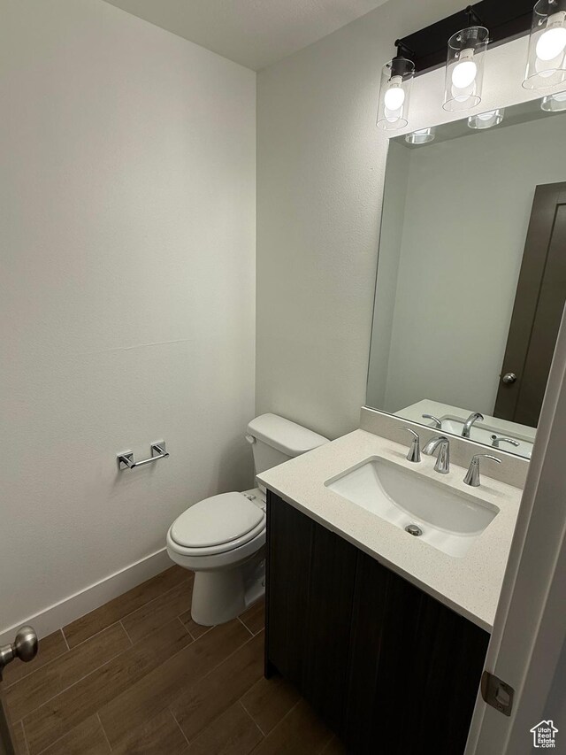 3049 S Orchard Dr Unit B, Bountiful, UT 84010 - bathroom featuring vanity, baseboards, toilet, and wood finished floors