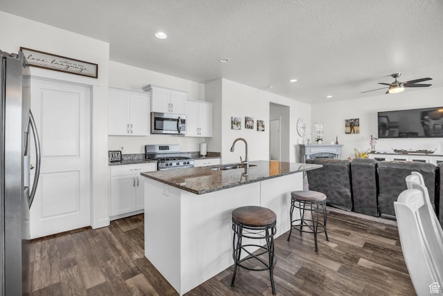 14843 S Beckenbauer Ave, Herriman, UT 84096 - kitchen with a sink, appliances with stainless steel finishes, a breakfast bar, and dark wood-type flooring