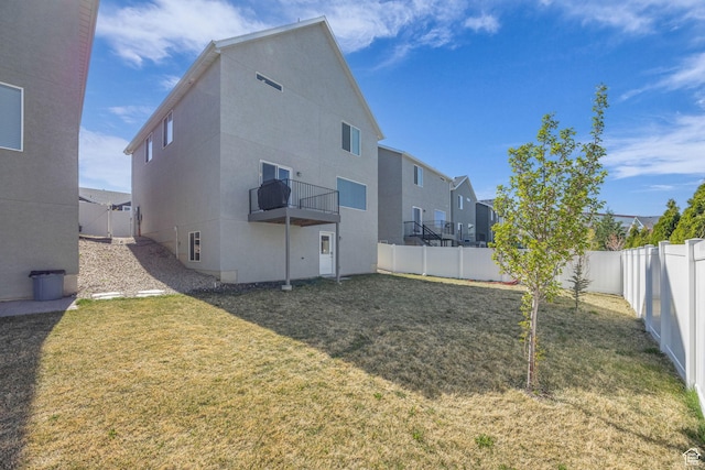 14843 S Beckenbauer Ave, Herriman, UT 84096 - rear view of house with a fenced backyard, stucco siding, a residential view, and a lawn
