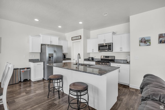 14843 S Beckenbauer Ave, Herriman, UT 84096 - kitchen with appliances with stainless steel finishes, a kitchen breakfast bar, a textured ceiling, dark wood finished floors, and a sink