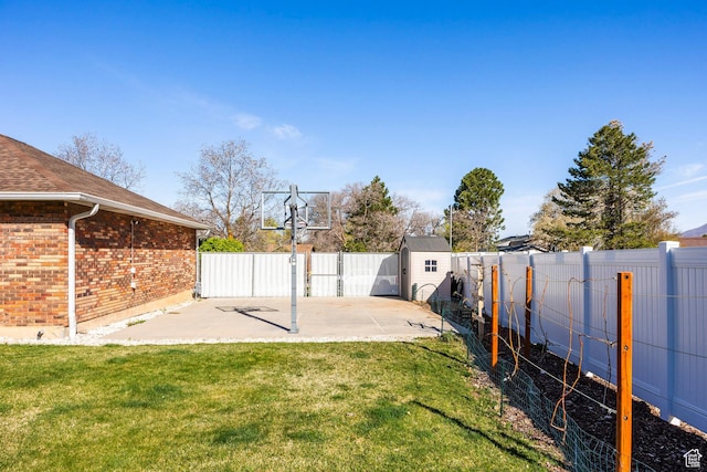 view of basketball court with a fenced backyard, a lawn, and a storage unit