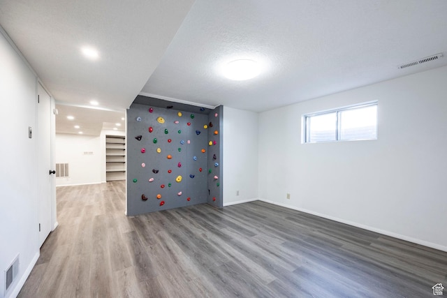 spare room with visible vents, baseboards, and wood finished floors