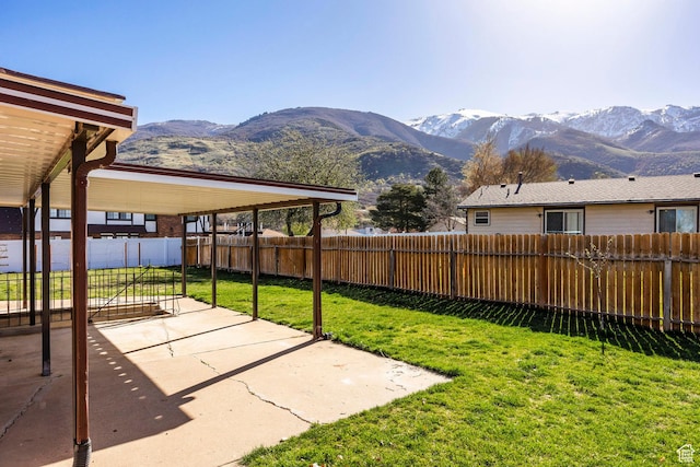 view of yard with a patio, a mountain view, and a fenced backyard