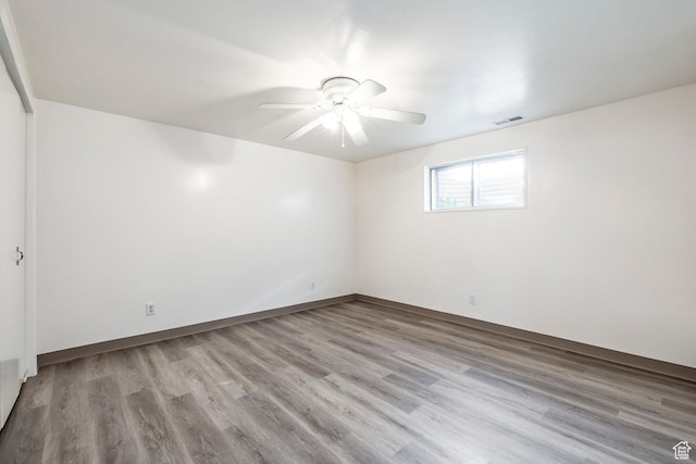 unfurnished room with visible vents, a ceiling fan, and wood finished floors