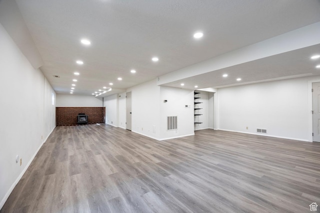 basement with wood finished floors, baseboards, visible vents, and recessed lighting