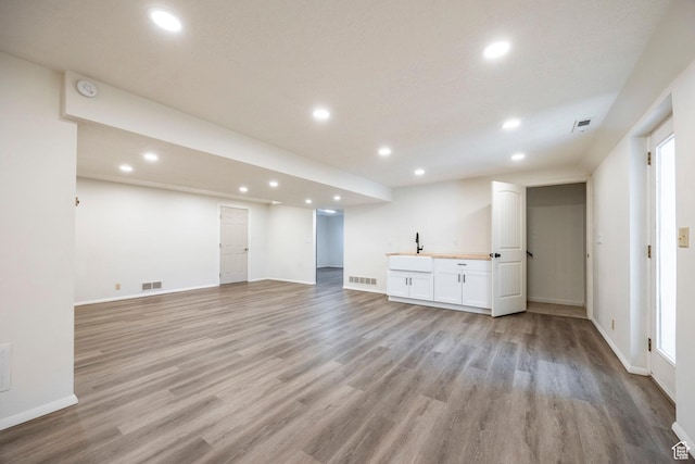 unfurnished living room with light wood-type flooring, visible vents, and recessed lighting