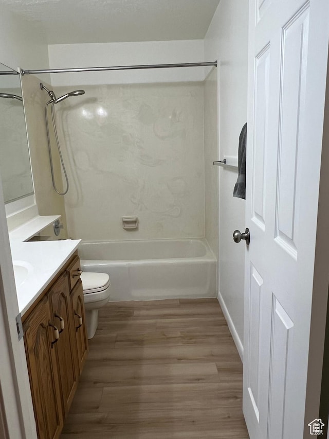 full bathroom with toilet, wood finished floors, vanity, and shower / bathing tub combination