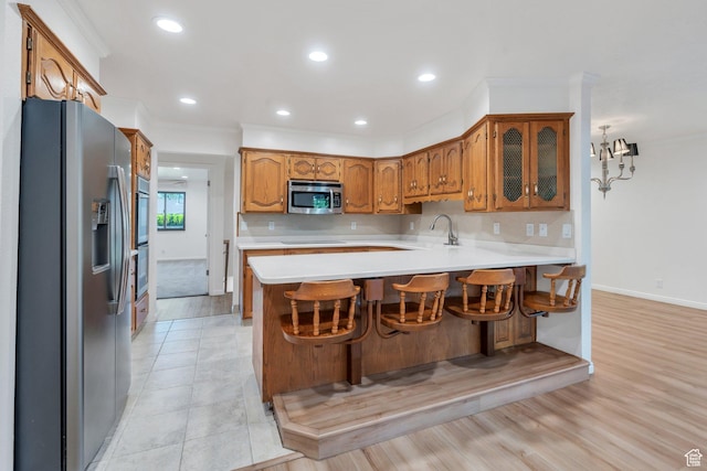 1769 Cobblestone Dr, Provo, UT 84604 - kitchen with appliances with stainless steel finishes, a peninsula, light countertops, brown cabinets, and recessed lighting