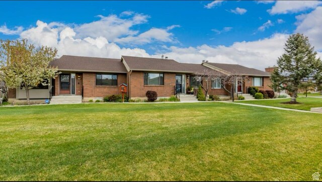 single story home featuring a front yard and brick siding