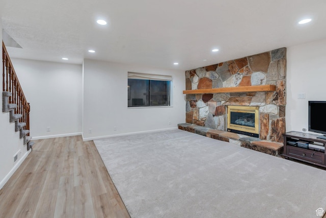 1769 Cobblestone Dr, Provo, UT 84604 - unfurnished living room with light wood-type flooring, recessed lighting, a stone fireplace, and stairs