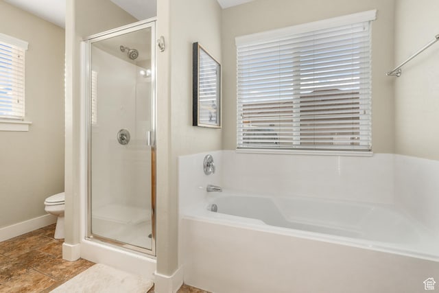 bathroom with toilet, baseboards, a garden tub, and a stall shower