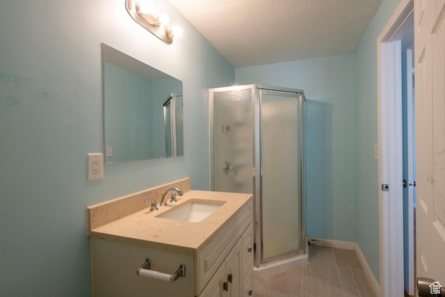 full bath with a shower stall, vanity, and baseboards