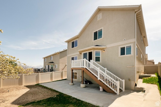 back of property with a patio area, a fenced backyard, stairway, and stucco siding