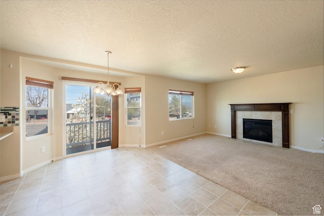 unfurnished living room featuring plenty of natural light, a notable chandelier, and a textured ceiling