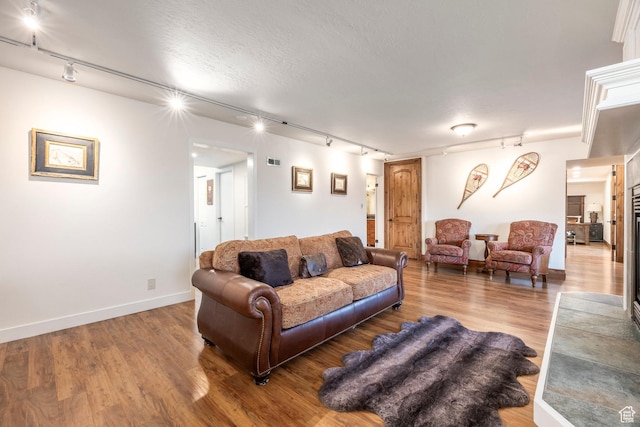 living room featuring visible vents, wood finished floors, and track lighting