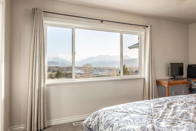 carpeted bedroom featuring visible vents, multiple windows, and baseboards