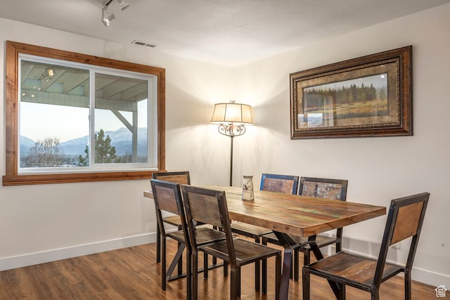 dining space with visible vents, baseboards, a mountain view, and dark wood-style floors