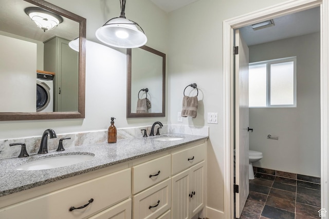 full bath featuring washer / clothes dryer, double vanity, a sink, and toilet