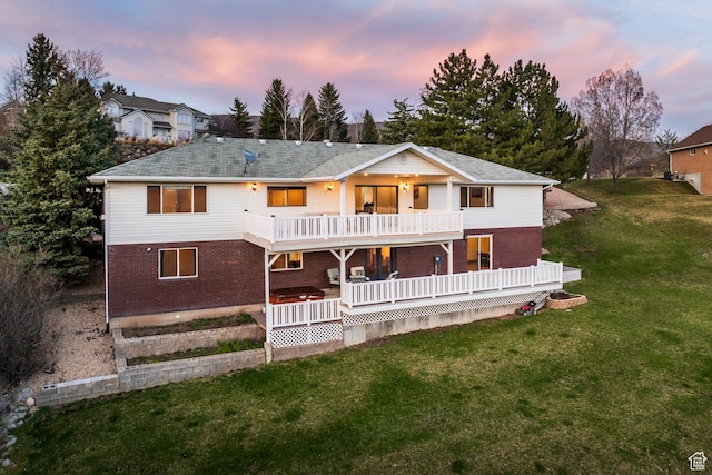 view of front of home with a yard, brick siding, and a balcony
