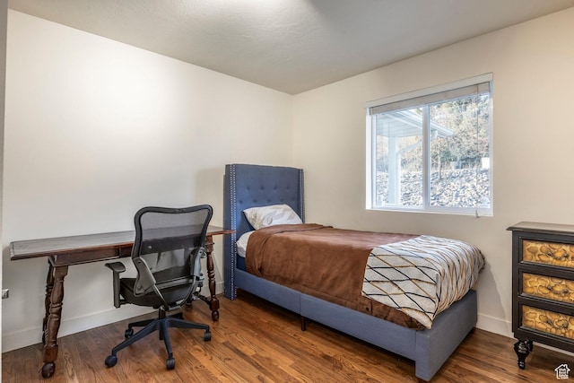 bedroom featuring baseboards and wood finished floors