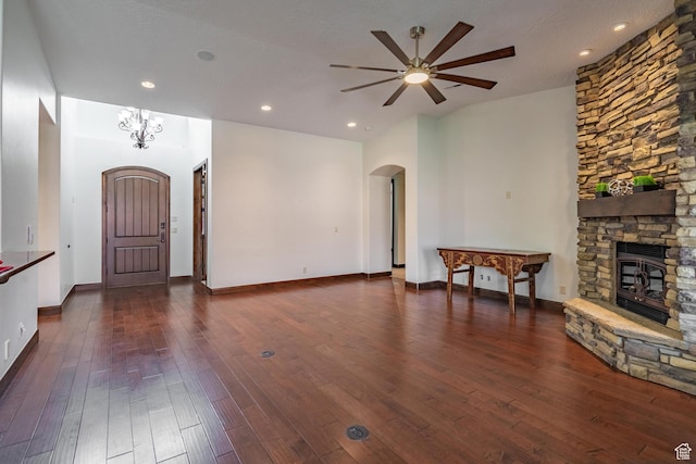 1844 N Wellington St, Washington, UT 84780 - unfurnished living room featuring recessed lighting, dark wood-style flooring, a stone fireplace, ceiling fan with notable chandelier, and arched walkways