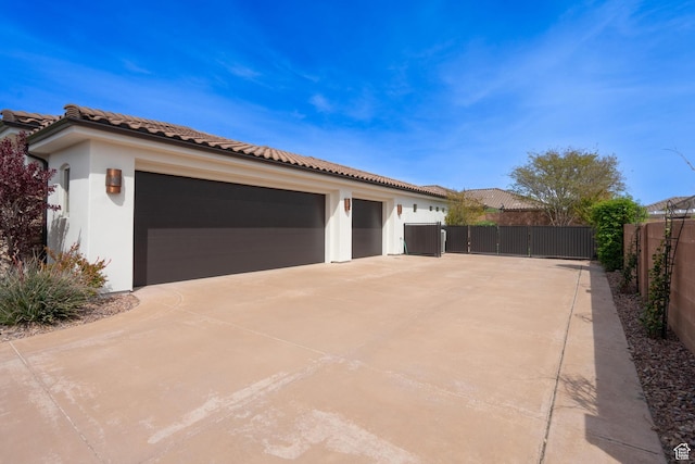 1844 N Wellington St, Washington, UT 84780 - view of side of home with a gate, stucco siding, a tile roof, fence, and concrete driveway