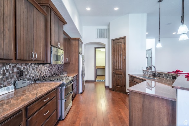 1844 N Wellington St, Washington, UT 84780 - kitchen with a sink, stainless steel appliances, visible vents, backsplash, and arched walkways