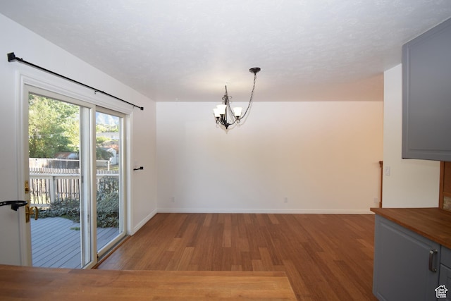 9111 S Parakeet Dr, Sandy, UT 84093 - unfurnished dining area featuring a chandelier, baseboards, and wood finished floors